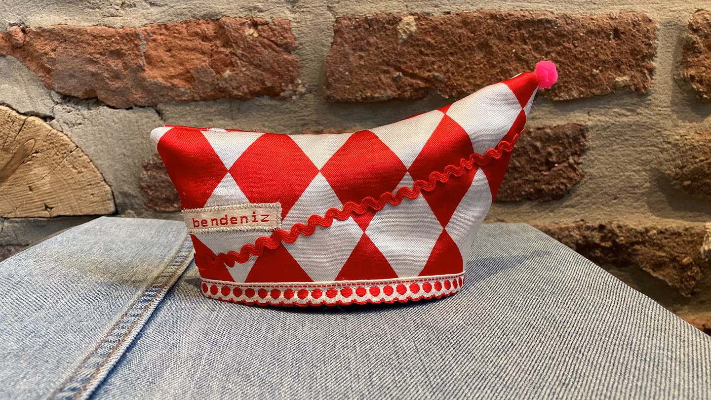 Eine rot-weiße Narrenkappe mit niedlichen Verzierungen und Bommel