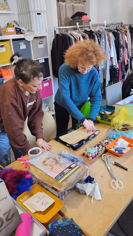 Narrenkappenworkshop_IGLU_Tisch_260201_450x800 Deniz vom IGLU erklärt einer Workshopteilnehmerin, wie sie die Schnitte ihrer Narrenkappe am besten mit Naden feststeckt