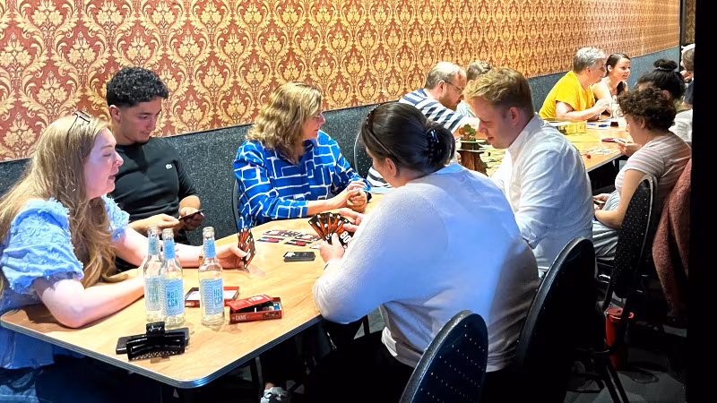 Spieletag im GLORIA Sommercafé Eine Gruppe Leute spielt im GLORIA Sommercafé und diskutiert angeregt